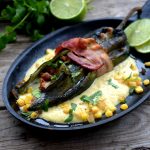Stuffed poblano wrapped in bacon in cream corn sauce