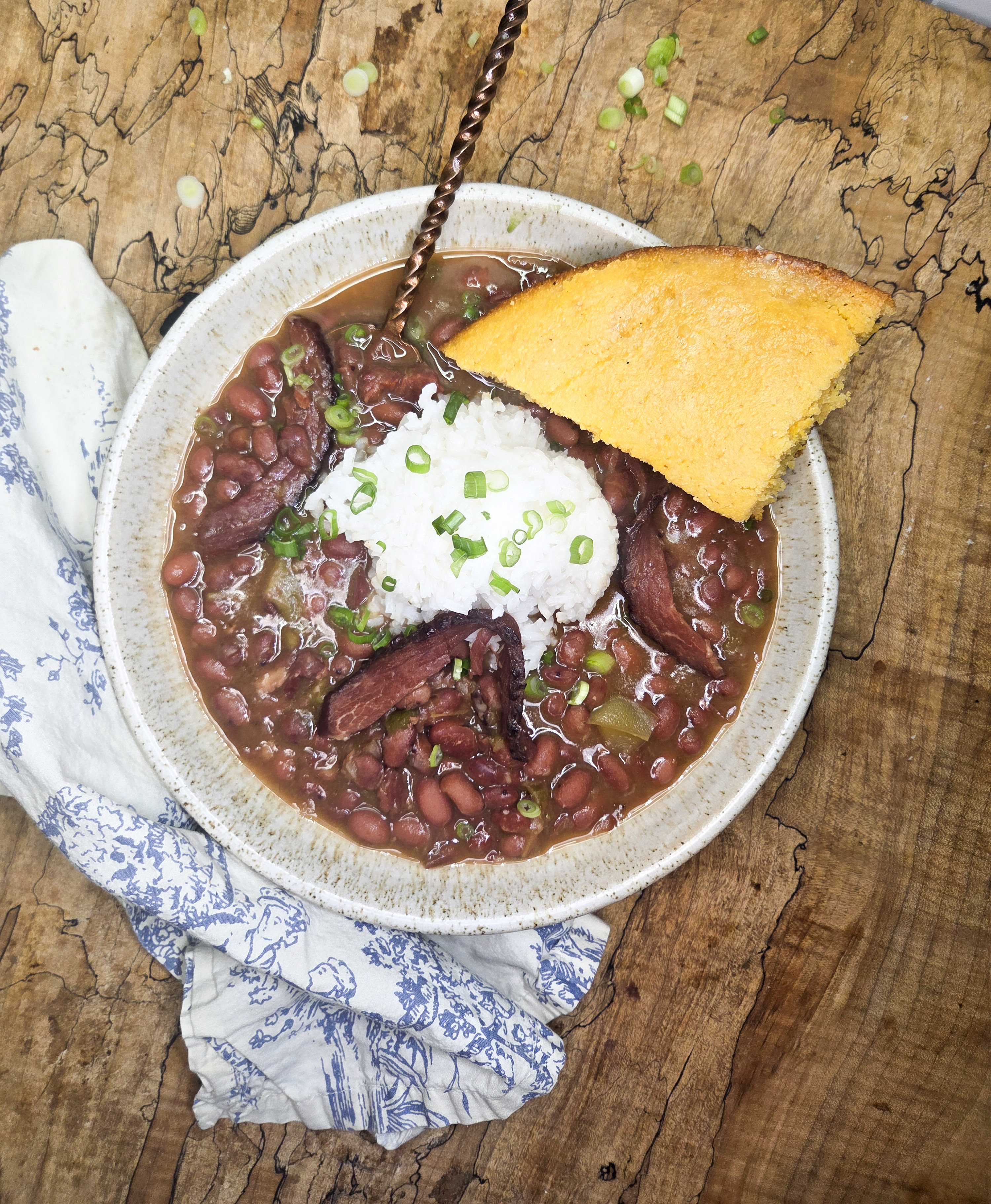 Red Beans and Rice is a slow cooked classic made with leftover ham bone, the holy trinity and signature spices served over white rice.