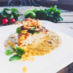 Halibut in roasted tomatillo sauce with crispy fried onions