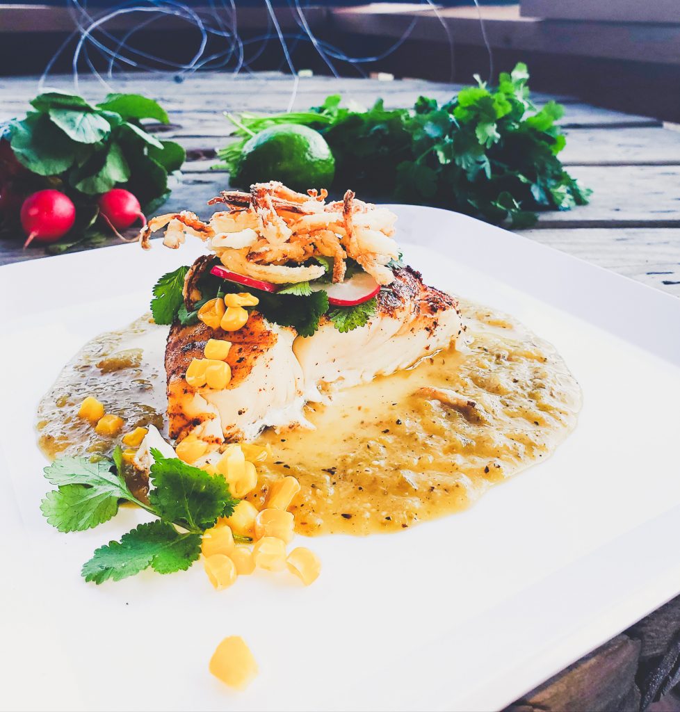 Halibut in roasted tomatillo sauce with crispy fried onions