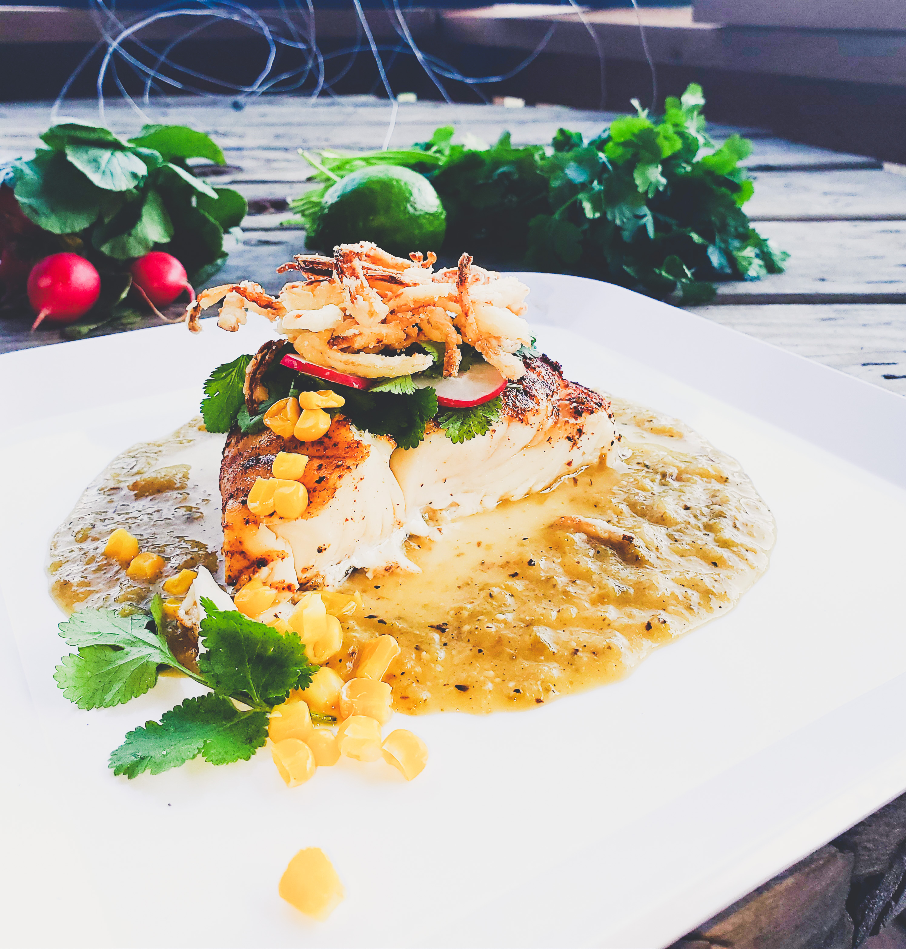 Halibut in roasted tomatillo sauce with crispy fried onions