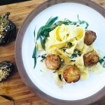 Seared sea scallops get twilled in a light lemon shallot cream sauce and accented with tarragon.