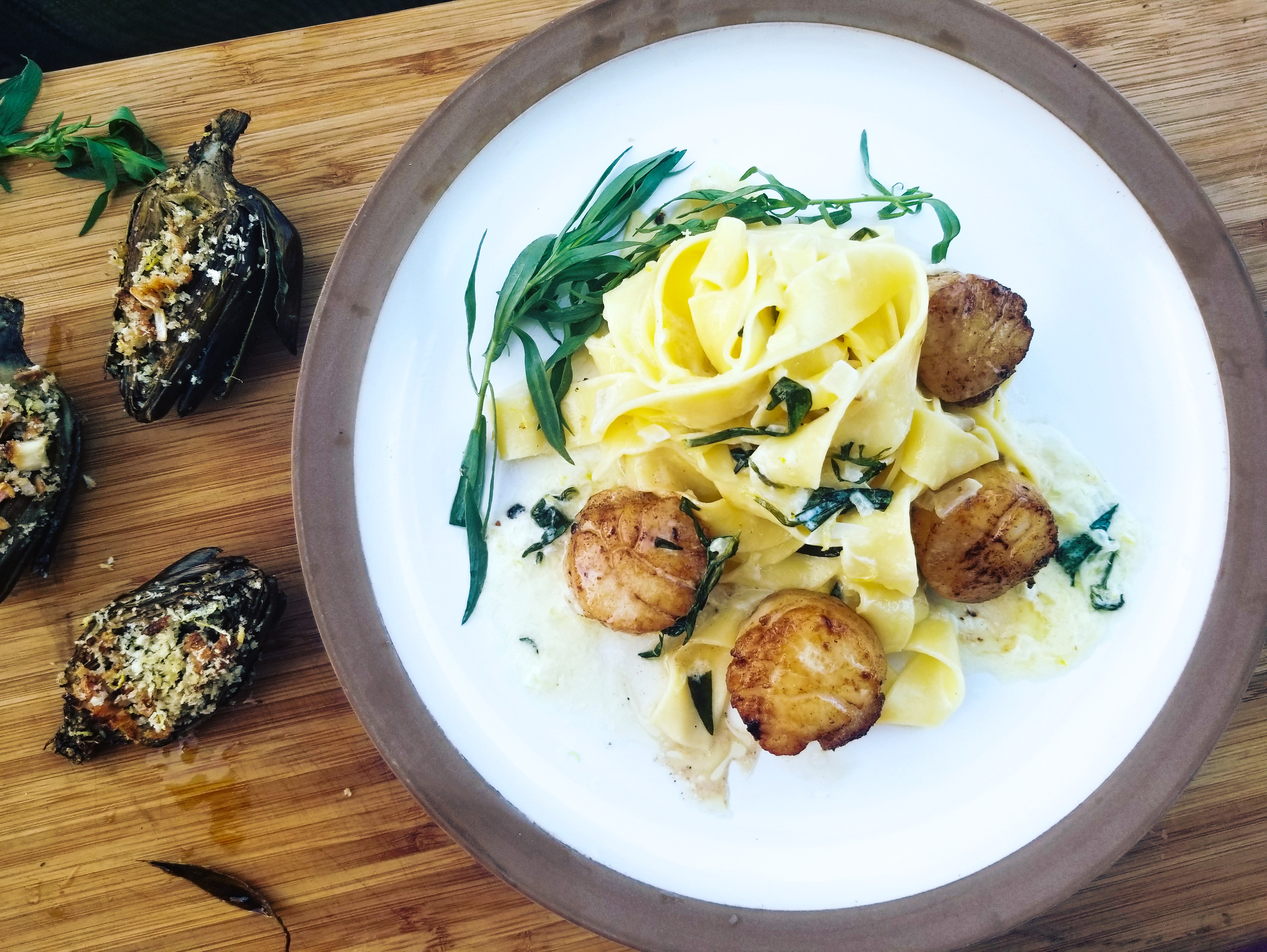 Seared sea scallops get twilled in a light lemon shallot cream sauce and accented with tarragon.