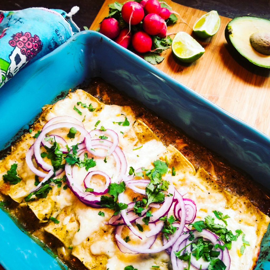 Creamy, cheesy Enchiladas Suiza uses a tomatillo base and is topped with thinly sliced red onion and cilantro