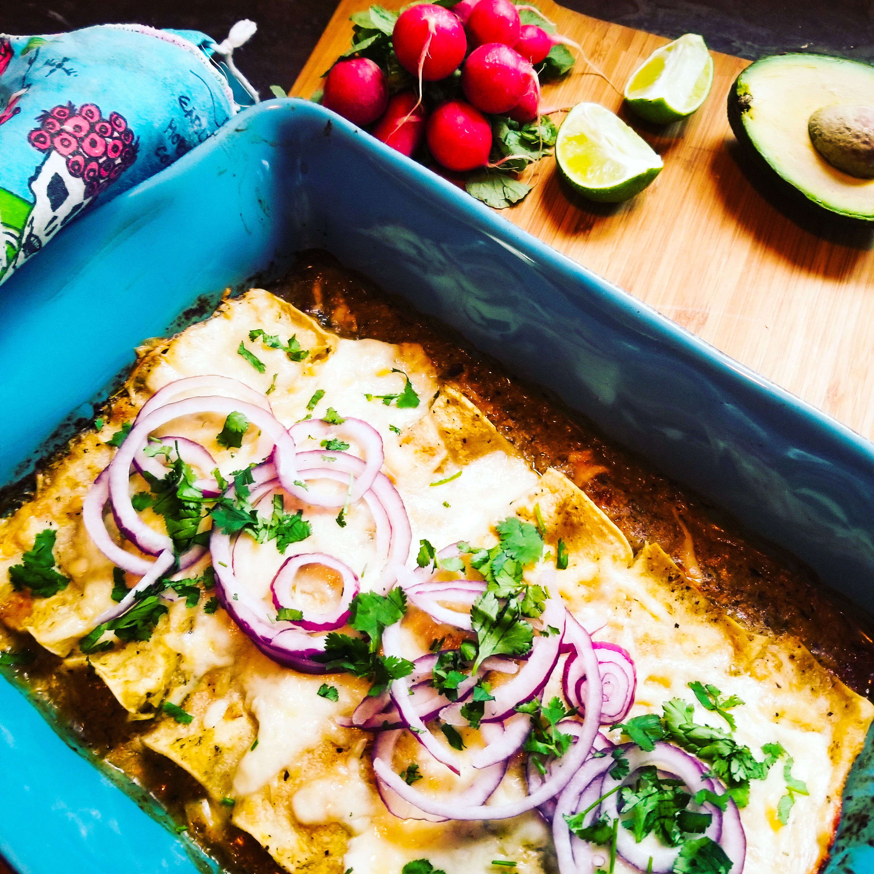 Creamy, cheesy Enchiladas Suiza uses a tomatillo base and is topped with thinly sliced red onion and cilantro