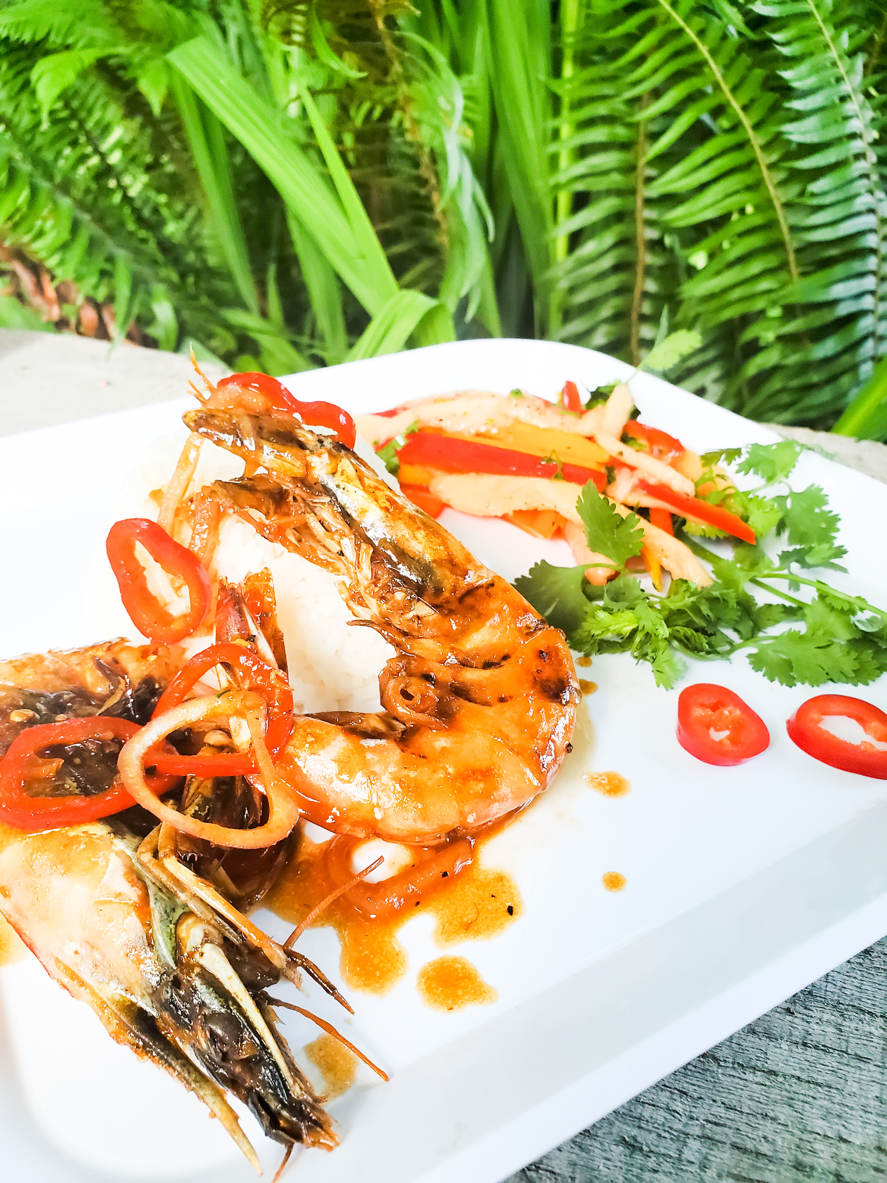 Chili- Garlic Head On Shrimp deliver all the flavor with papaya salad drizzled in hot honey and lime juice and coconut lime rice.