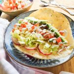 Crispy flour tortilla with cumin beans, fresh vegetables