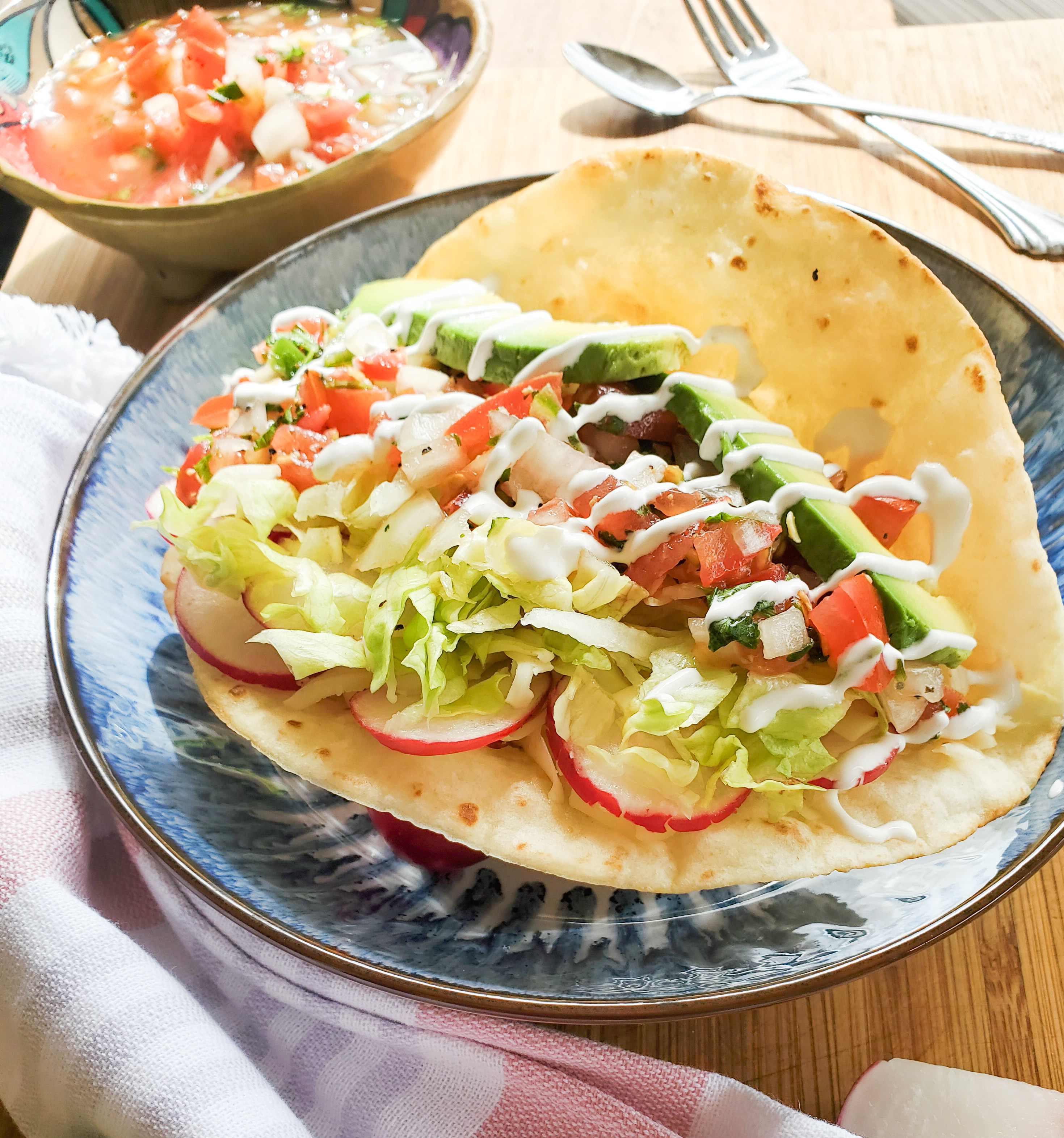 Crispy flour tortilla with cumin beans, fresh vegetables