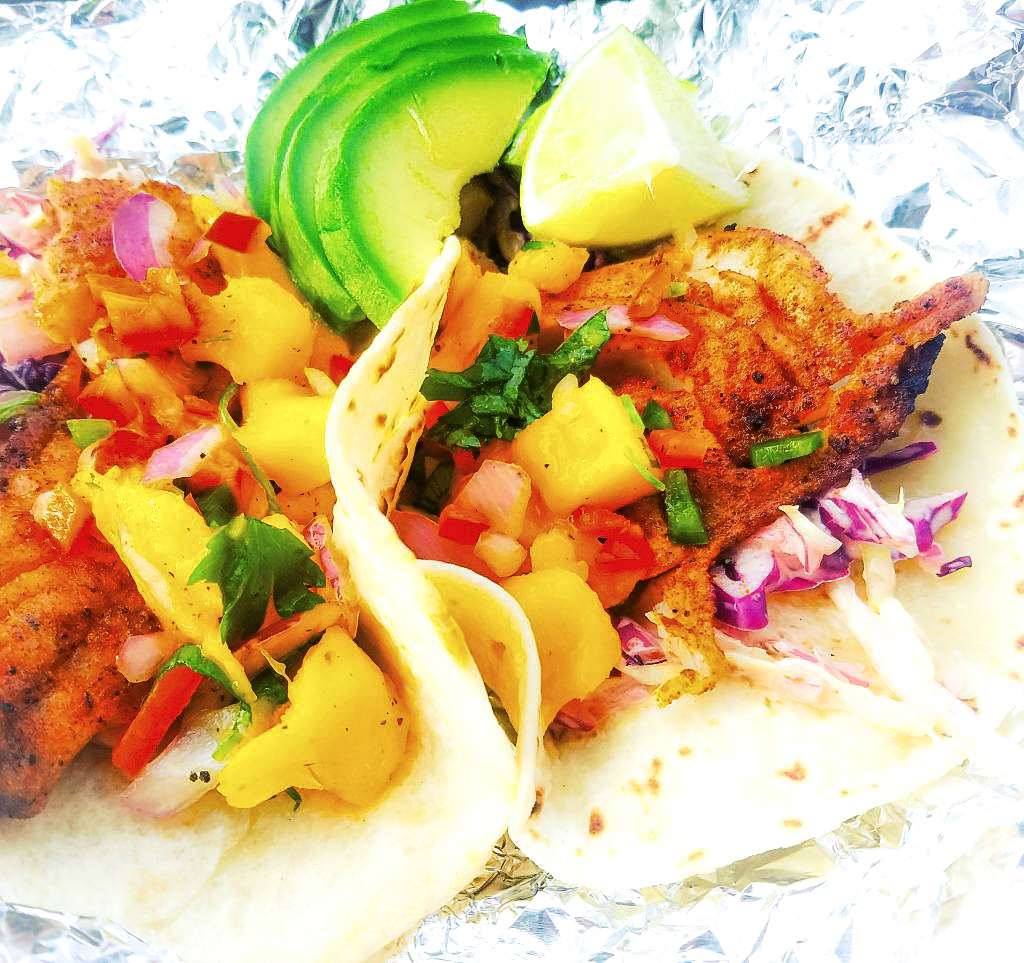 Nearly guilt free, these Grilled Pacific Rock Fish Tacos skip the typical dredging and go straight for the grill. Topped with fresh mango salsa and served in a warm flour tortilla with chipotle slaw.