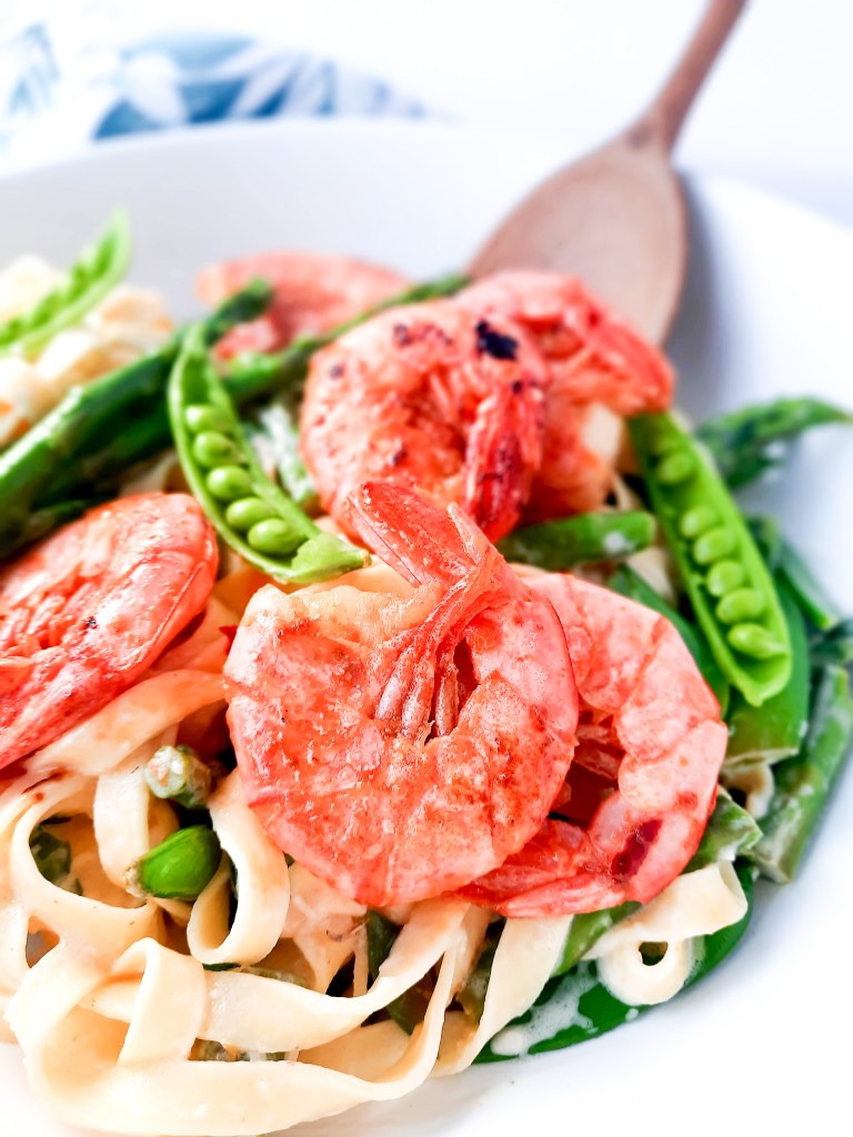 Creamy Spring Pasta with Shrimp combines first of the season asparagus and peas in a cream based sauce with tender garlic shrimp.