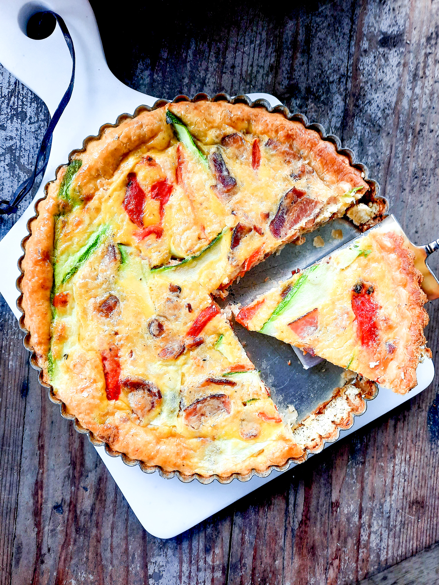 New Woman Cheese, Bacon, Zucchini and Roasted Red Pepper Quiche takes flavor from Jamaican jerk spiced cheese, farm eggs and a butter crust.
