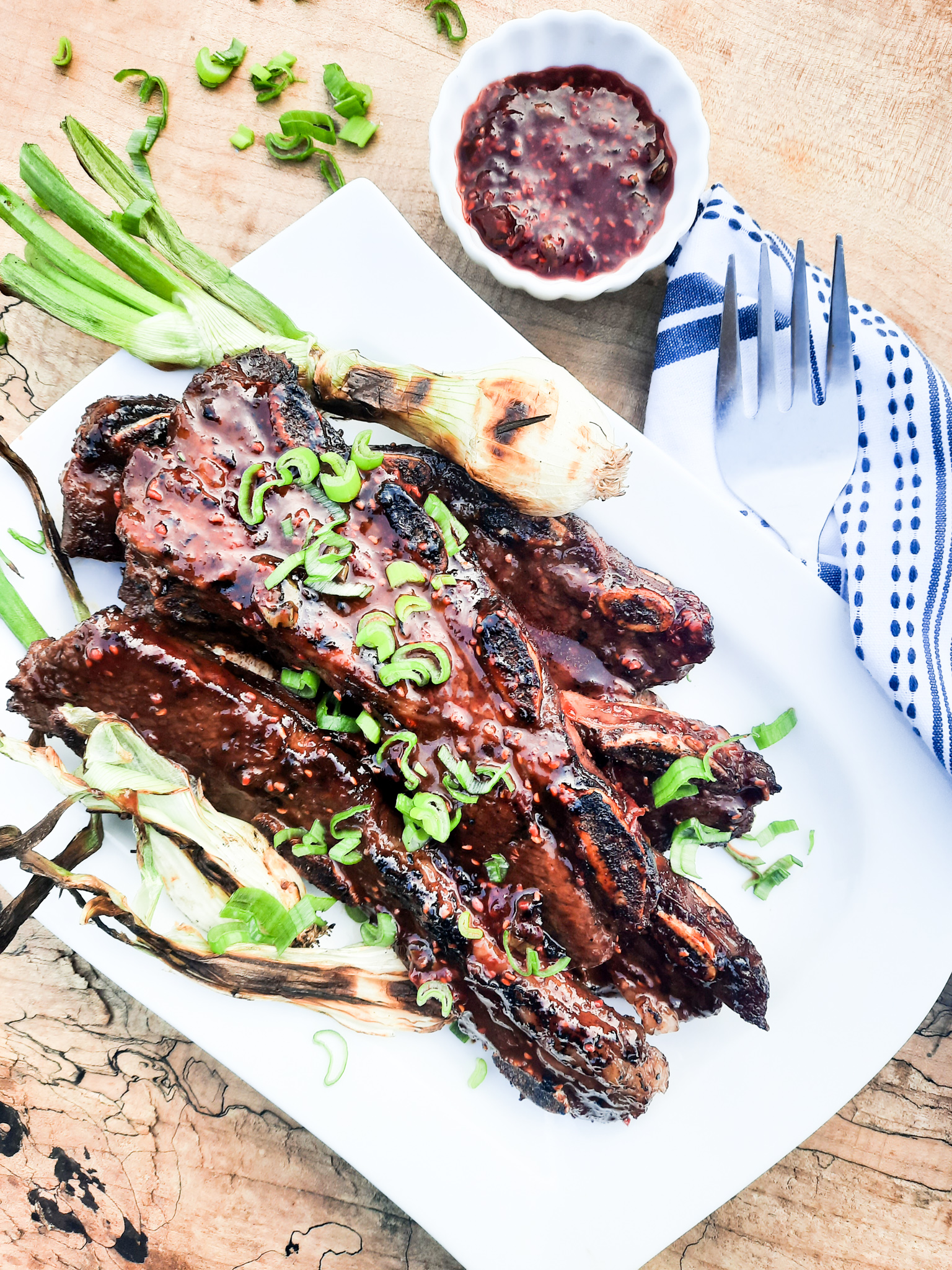 Flanken-Cut Short Ribs marinated in a sweet and slightly smoky raspberry chipotle sauce then grilled and garnished with chopped onion tops.