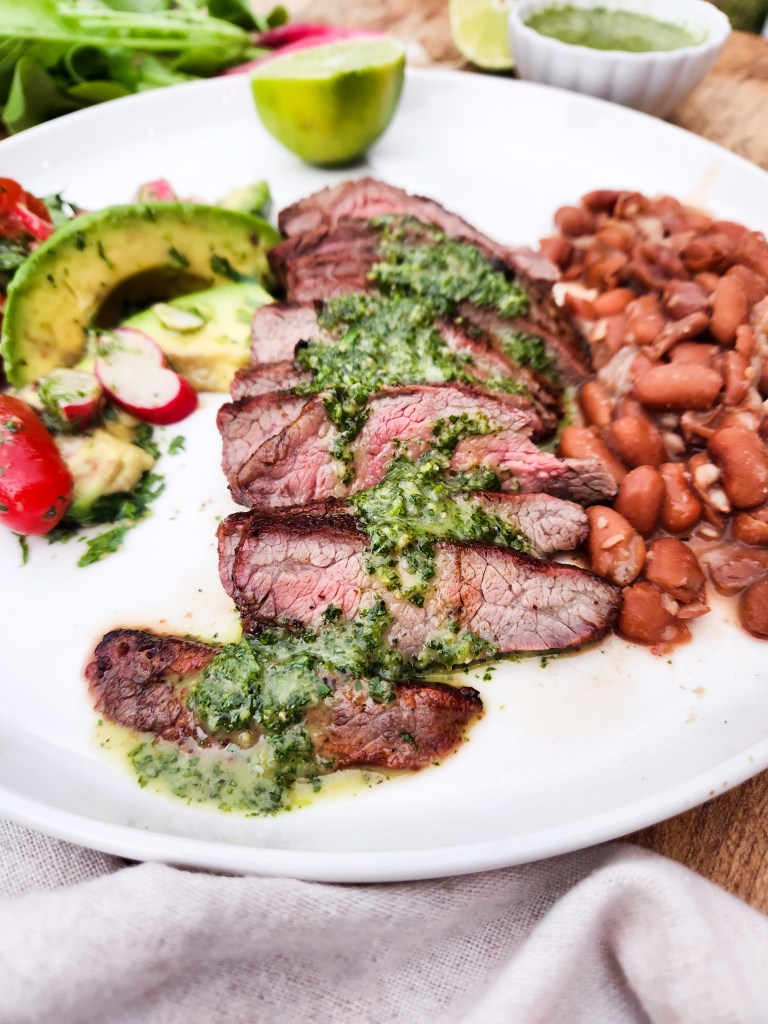 Cilantro Chimichurri Flank Steak is seasoned, quickly grilled and served sliced with fresh cilantro chimichurri sauce and sides.