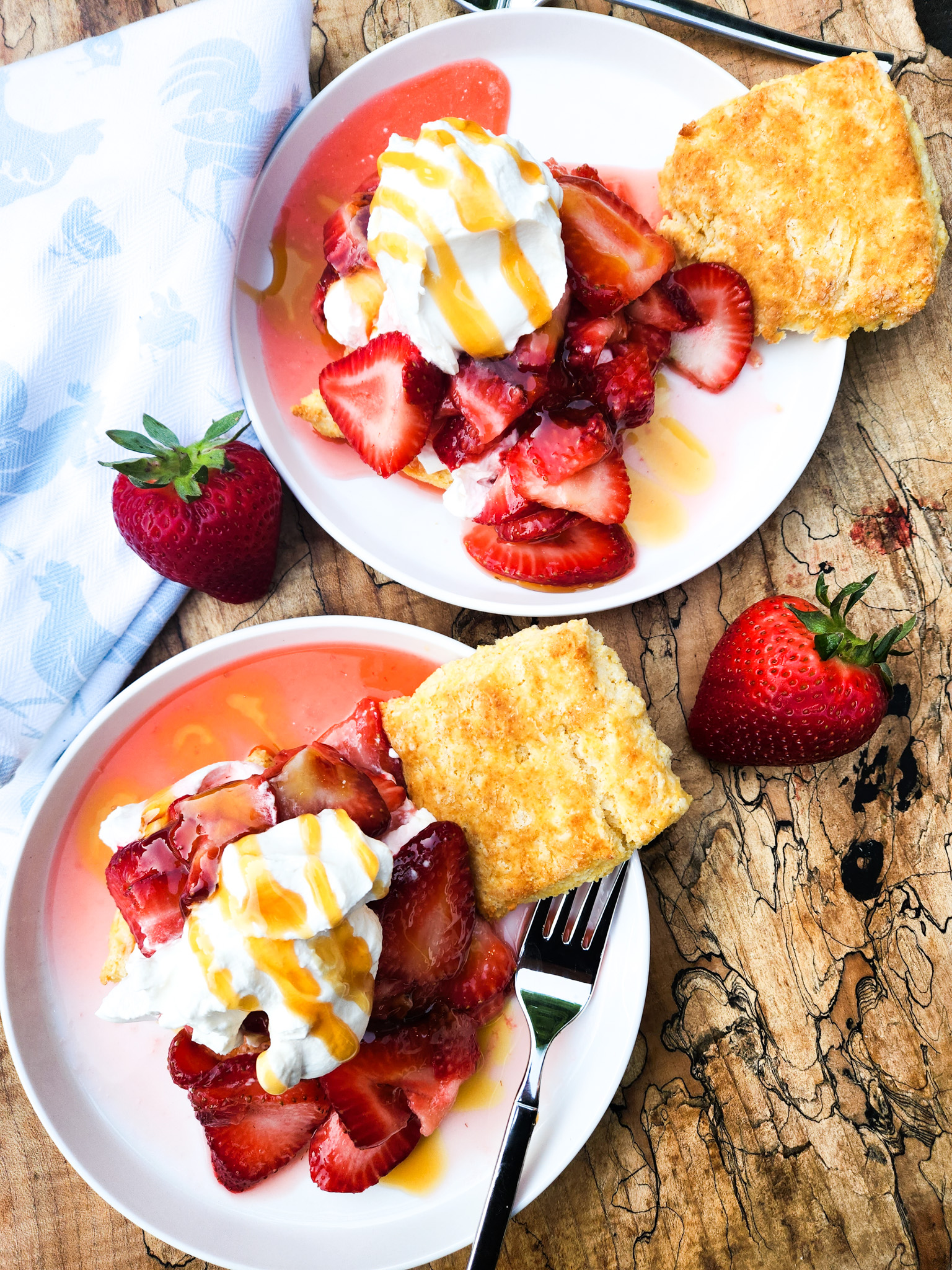 Hot Honey Strawberry Shortcake layers fresh sliced strawberries with cornmeal biscuits, whipped cream and a hot honey drizzle.