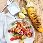 Mexican Grilled Shrimp Bowls with tomato avocado salsa, grilled corn and cilantro lime crema over fluffy white rice.