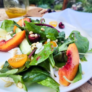 Stone Fruit Salad layers fresh, seasonal nectarine, cherry, cucumber, tomato, greens and pine nuts over ricotta with agave lime vinaigrette.