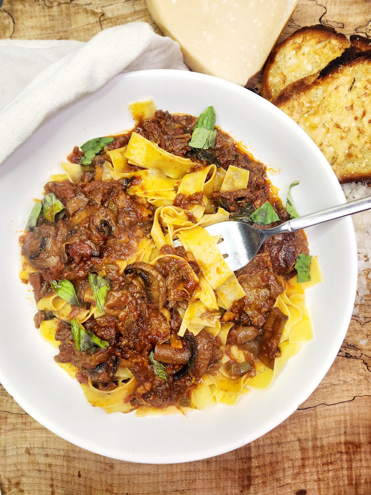Beef Short Rib Ragu is slow cooked for a rich, flavorful sauce of tender beef, tomatoes and mushrooms served over pappardelle pasta.