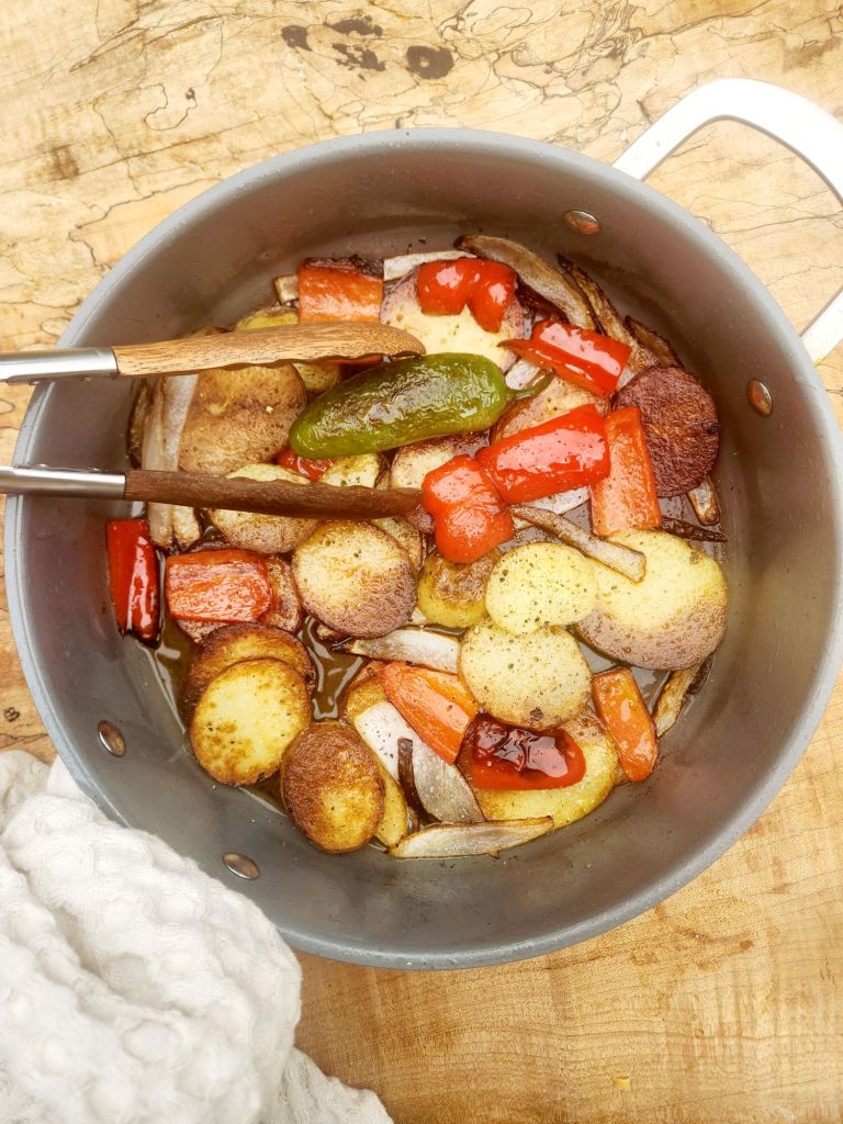 Country Style Potatoes are thick sliced yellow potatoes fried in bacon fat for an extra crispy crust with red pepper, jalapeno and onion.