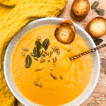 Acorn Squash Soup is warm and creamy with earthy spices like paprika, turmeric, cumin and chipotle, topped with fried sage and pepitas.