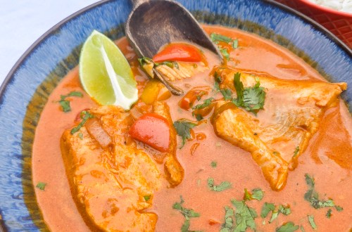 Brazilian Fish Stew with flakey cod poached in a flavorful spicy coconut tomato stew with red and yellow peppers and fresh lime.