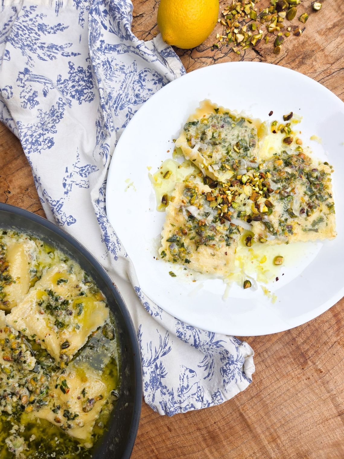 white plate with ravioli topped with pistachio pesto