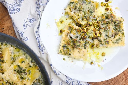 white plate with ravioli topped with pistachio pesto