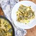 white plate with ravioli topped with pistachio pesto