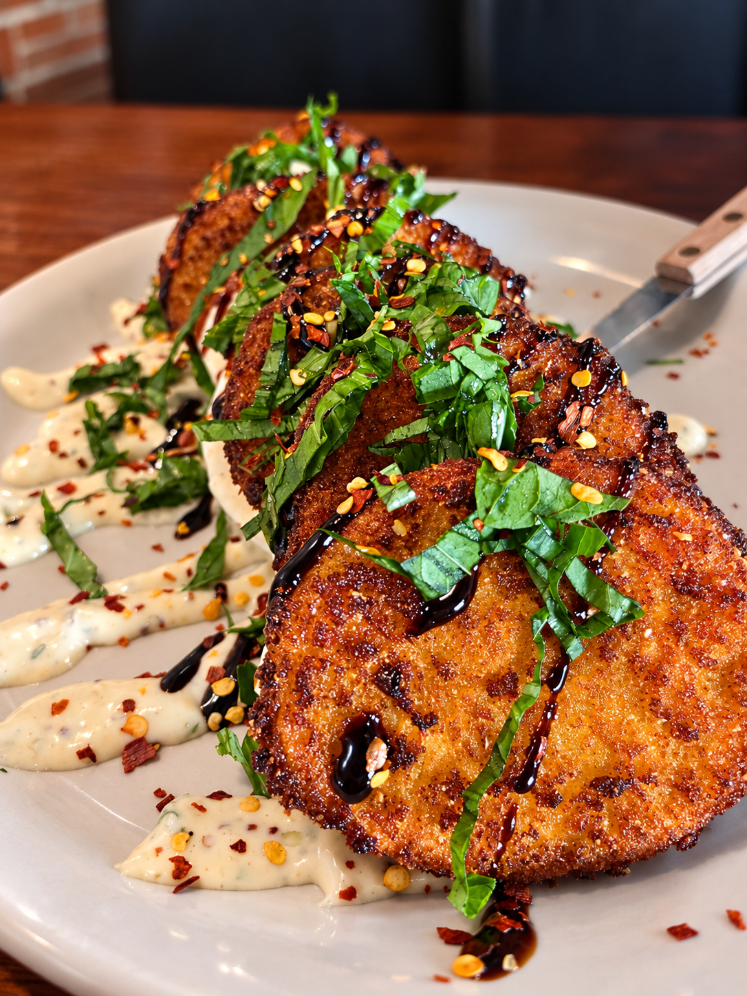 Layers of Fried Green Tomato Caprese with fresh basil