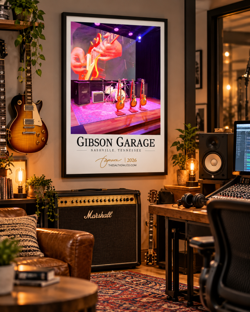 Gibson Garage Nashville travel photography print in a black frame displayed in a cozy music studio with guitars, vintage amplifiers, and warm lighting.